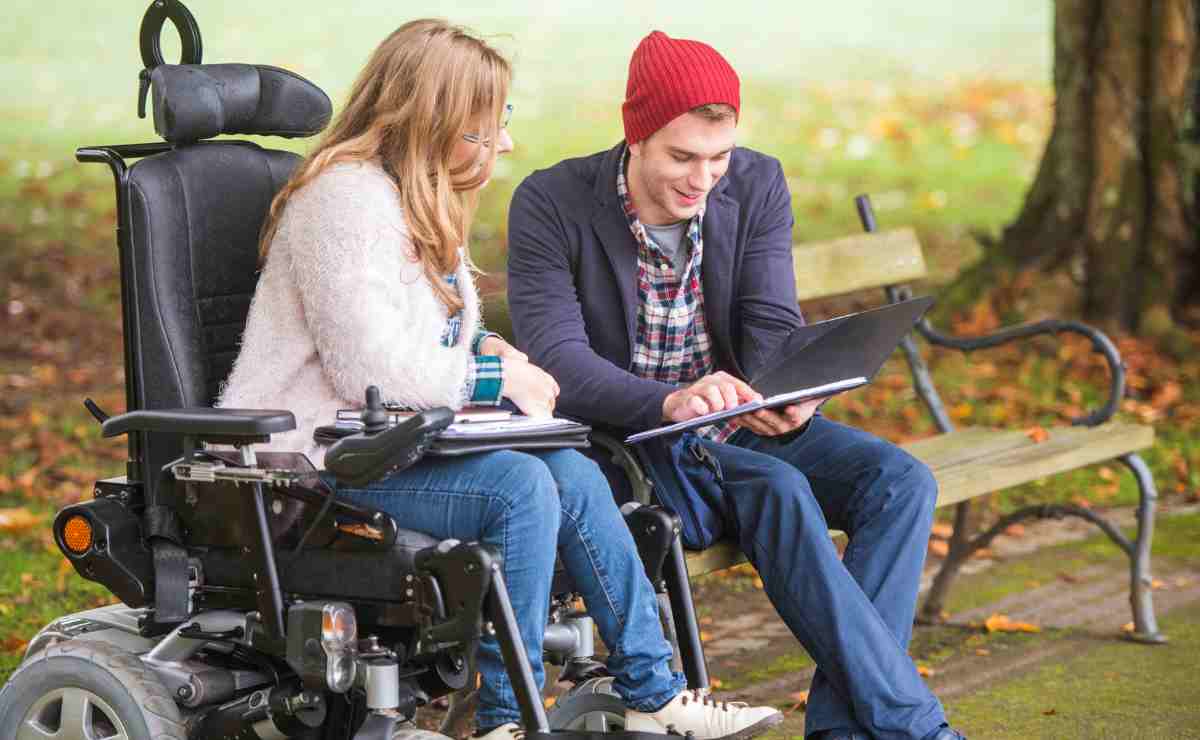 Woman with a disability and man outdoors looking at a tablet computer to talk aboutSSDI payments are about to arrive