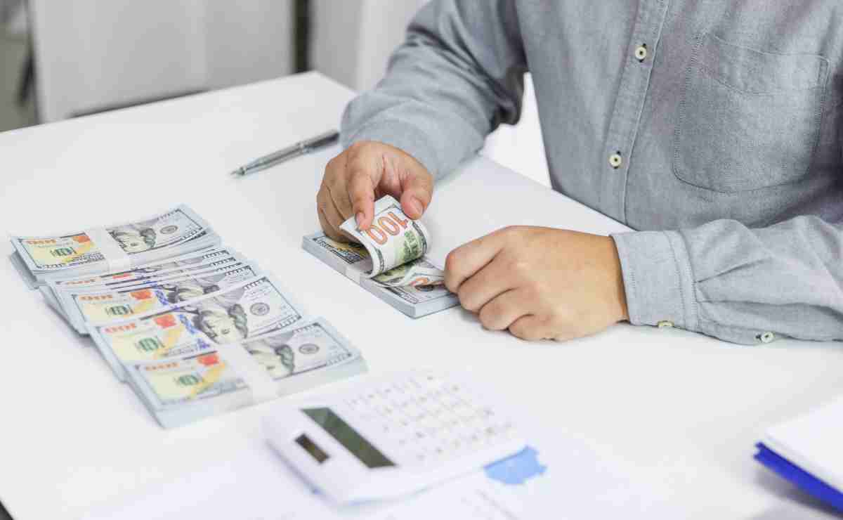 Man counting dollars because Social Security is sending checks of up to $4,555 today