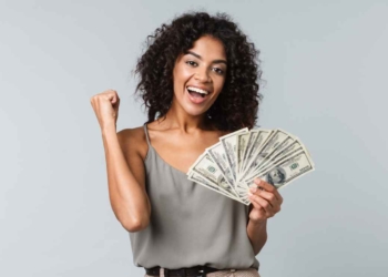 Woman with dollars celebrating to talk about States where you may receive a stimulus check payment