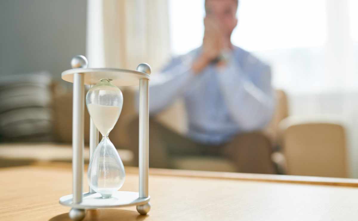 Hourglass and man worried so do not despair because it can take more than expected to get disability benefits