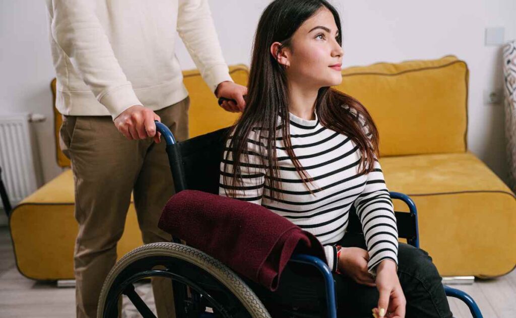 Woman on a wheelchair and man behind to talk about SSDI and the next payment