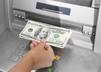 Hand with dollars at ATM for Social Security payments next week