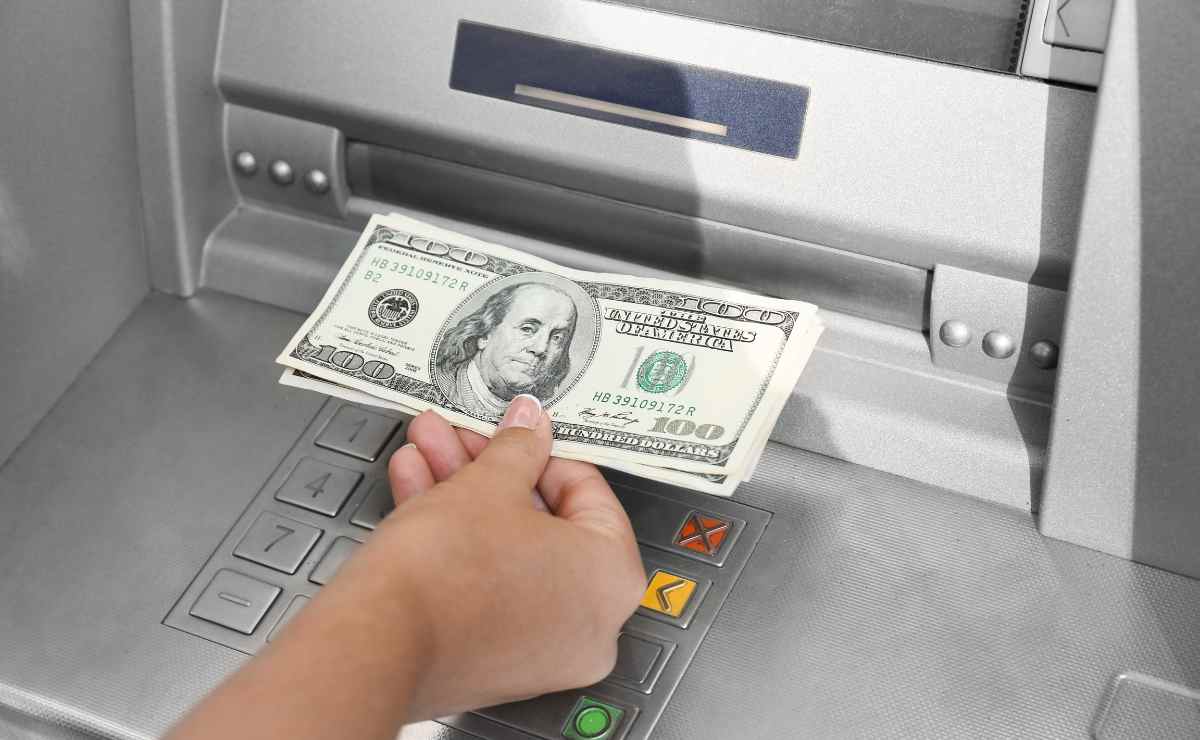 Hand with dollars at ATM for Social Security payments next week
