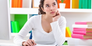 Mujer pensando con un Currículum Vitae