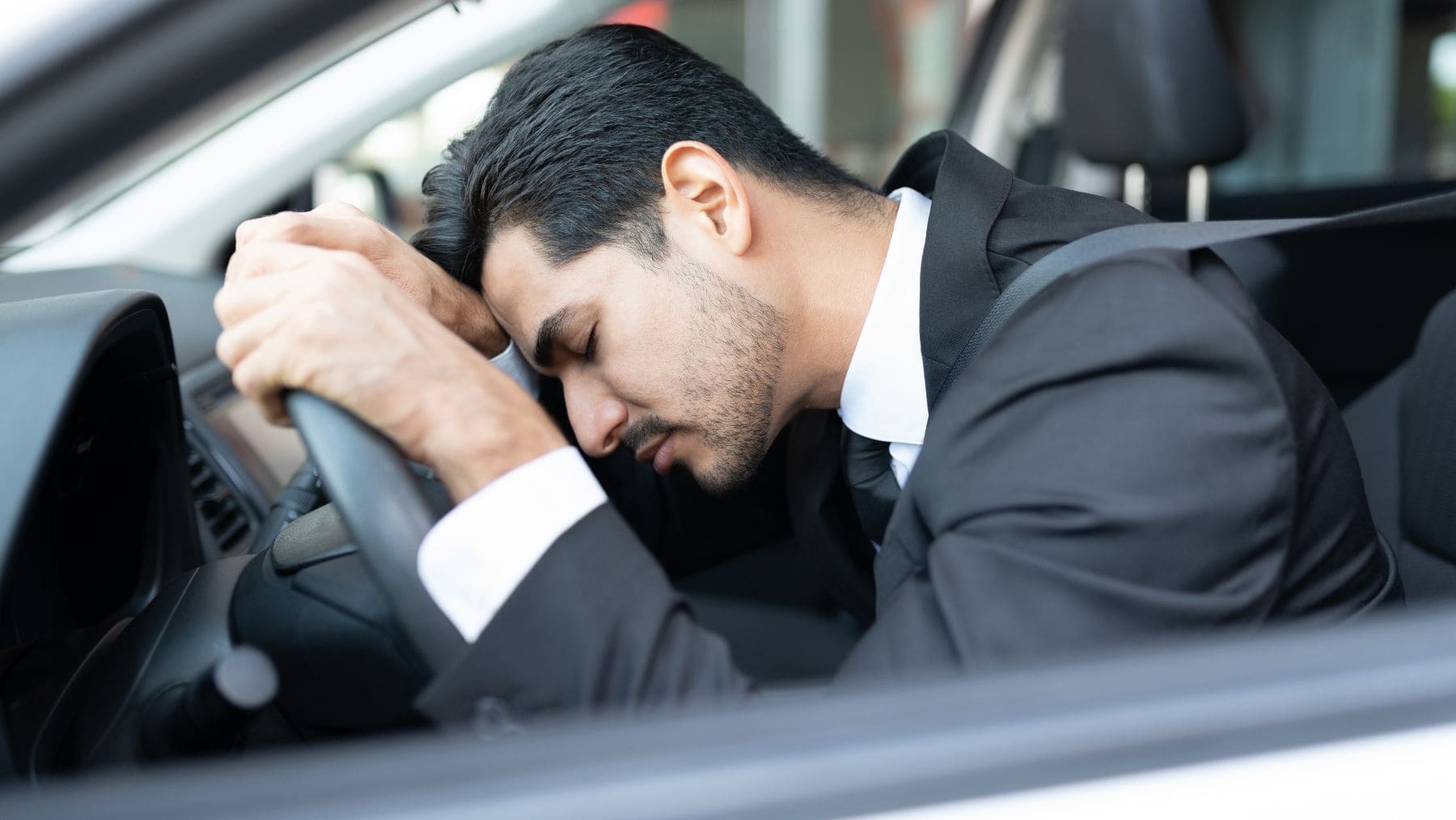 Hombre durmiendo en el volante del coche